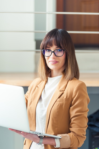 Junge Frau, die durch Laptop arbeitet