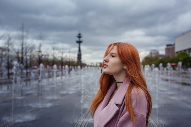 Junge Frau, die durch Moskauer Straßen geht. Spaziergang auf der Promenade. Gorky Park im zeitigen Frühjahr oder Herbst