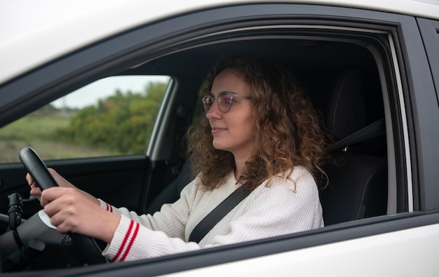 Foto junge frau, die ein autokonzept des neuen fahrers fährt