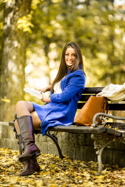 Junge Frau, die ein Buch im Park liest