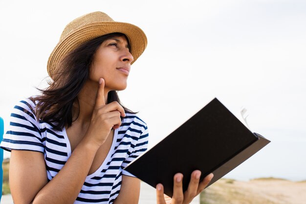 Junge Frau, die ein Buch in der Landschaft liest