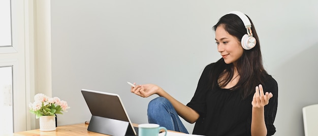 Junge Frau, die ein Computertablett beim Sitzen verwendet