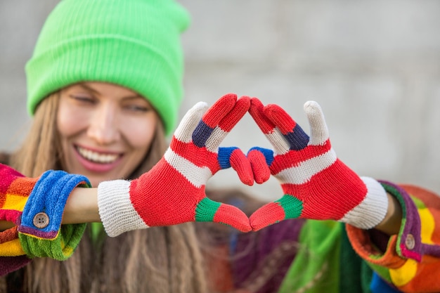 Junge Frau, die ein Herz aus Fingern macht Valentinstag-Konzept