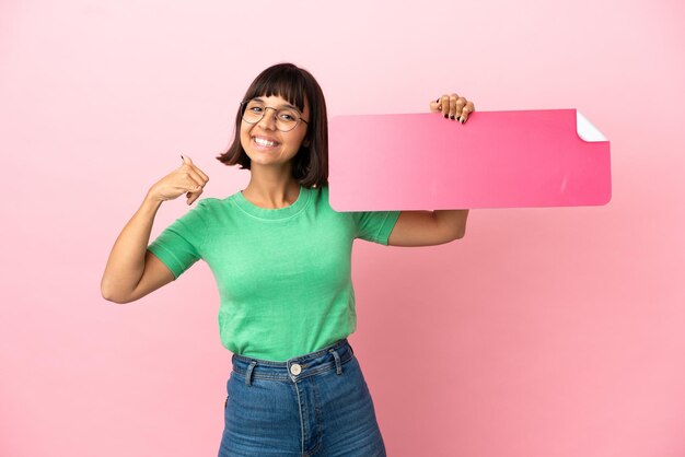 Junge Frau, die ein leeres Plakat hält und eine Telefongeste macht