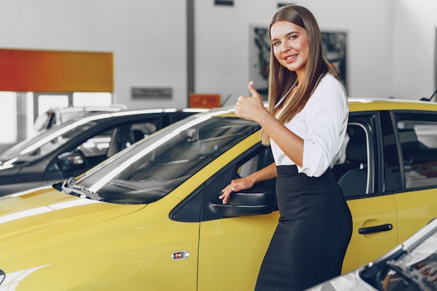 Junge Frau, die ein neues Auto auscheckt, das sie kaufen wird