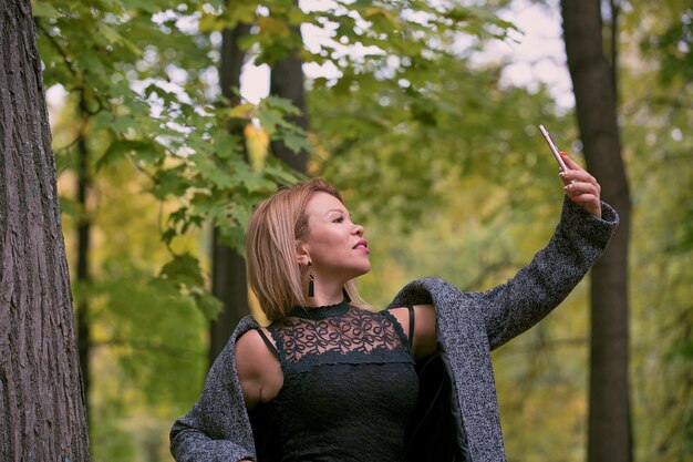 Junge Frau, die ein Selfie am Park nimmt