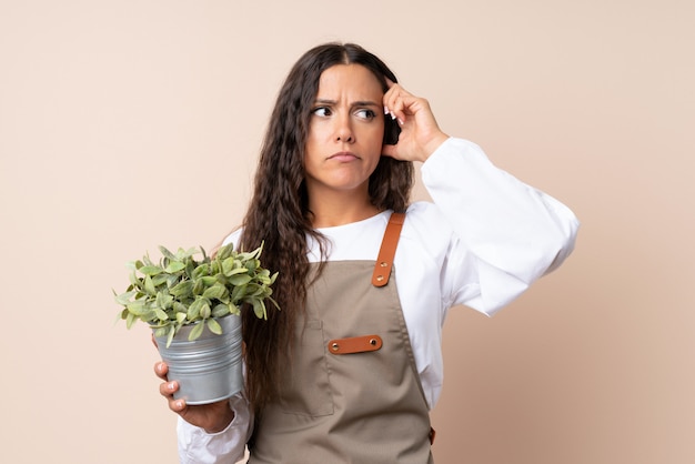 Junge Frau, die eine Anlage hat Zweifel und mit verwirren Gesichtsausdruck anhält