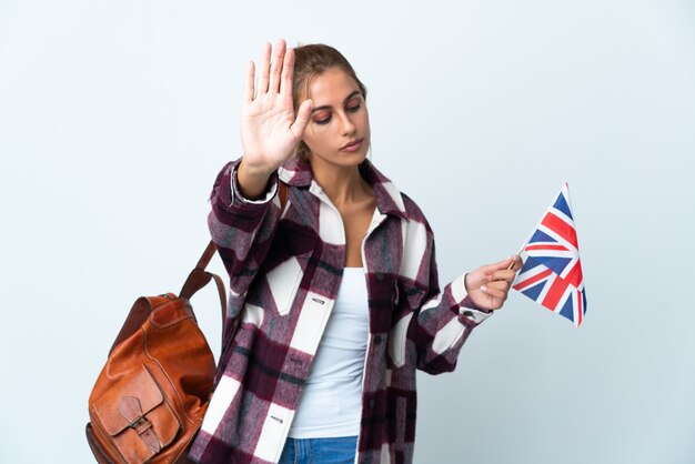 Junge Frau, die eine britische Flagge auf Weiß hält, macht Stoppgeste und enttäuscht