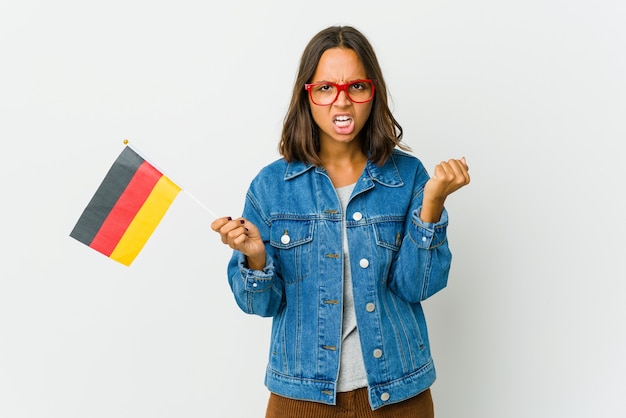 Junge Frau, die eine deutsche Flagge hält, die aggressiven Gesichtsausdruck zeigt