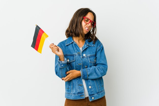 Junge Frau, die eine deutsche Flagge hält, die Ellbogen massiert und nach einer schlechten Bewegung leidet