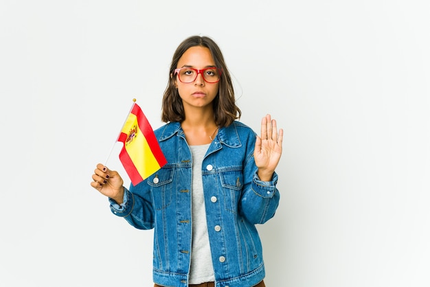 Junge Frau, die eine Flagge hält, die mit ausgestreckter Hand steht, die Stoppschild zeigt