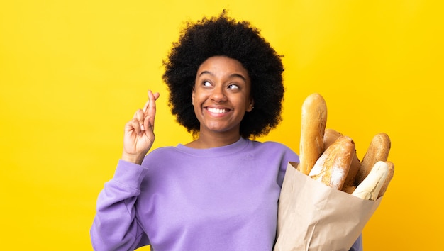 Junge Frau, die eine Papiertüte mit Brot hält