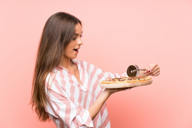 Junge Frau, die eine Pizza hält