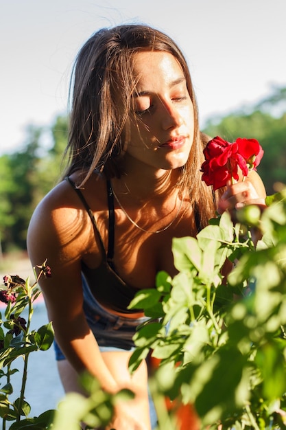 Junge Frau, die eine Rose in einem Feld auswählt