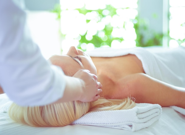 Junge Frau, die eine Spa-Massagebehandlung im Beauty-Spa-Salon bekommt