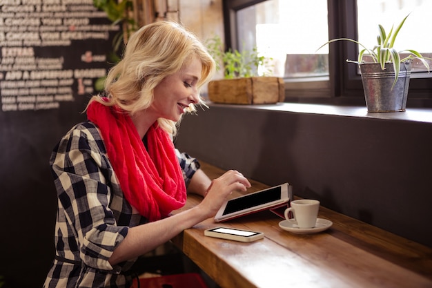 Junge Frau, die eine Tablette verwendet