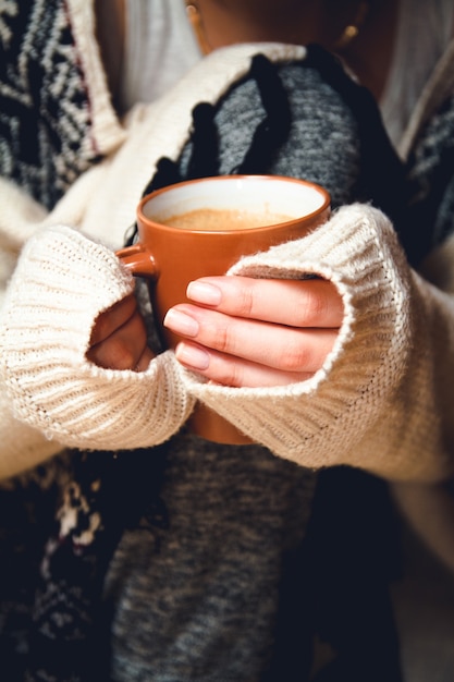 Foto junge frau, die eine tasse heißen kaffee in ihren händen hält