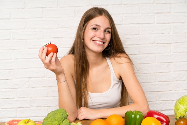 Junge Frau, die eine Tomate anhält