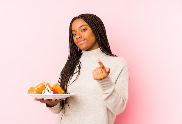 Junge Frau, die eine Waffel zeigt mit dem Finger hält