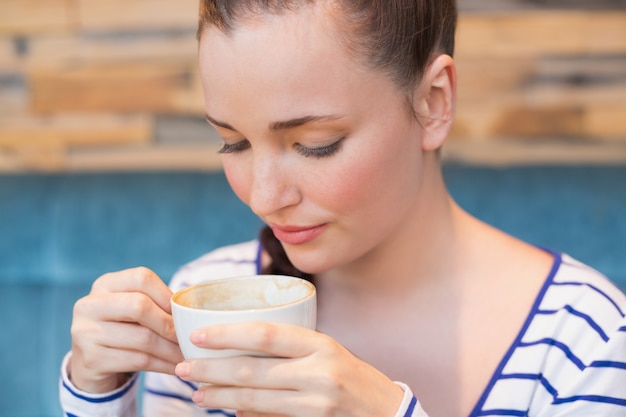 Foto junge frau, die einen cappuccino isst