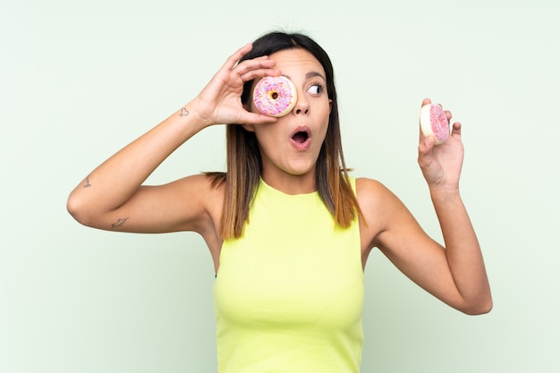 Junge Frau, die einen Donut über isoliert hält