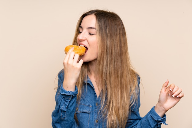 Junge Frau, die einen Donut über lokalisiert hält