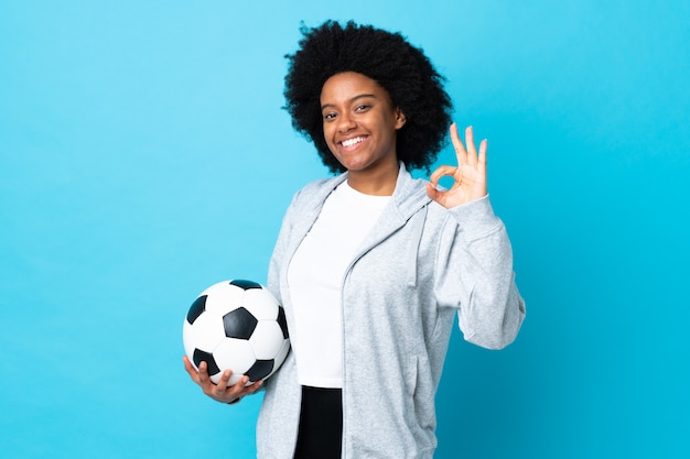 Junge Frau, die einen Fußball hält