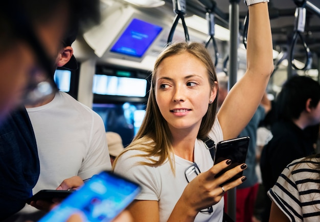 Junge Frau, die einen Smartphone in der U-Bahn verwendet