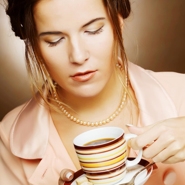 Junge Frau, die einen Tasse Kaffee hält