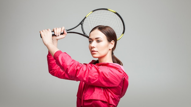 Junge Frau, die einen Tennisschläger hält