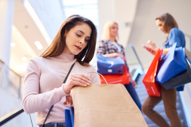 Junge Frau, die Einkaufstasche im Einkaufszentrum öffnet?