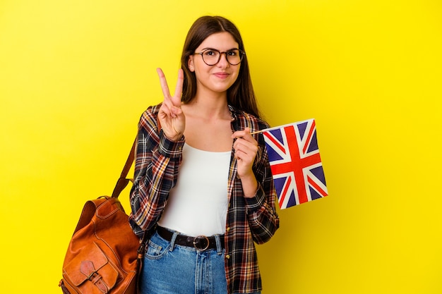 Junge Frau, die Englisch studiert, isoliert auf rosa Wand, die Nummer zwei mit den Fingern zeigt