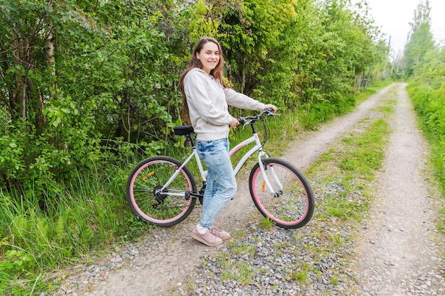 Junge Frau, die Fahrrad im Sommerstadtpark im Freien fährt Aktive Menschen Hipster-Mädchen entspannen sich und Fahrerfahrrad