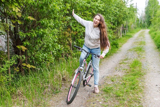 Junge Frau, die Fahrrad im Sommerstadtpark im Freien fährt Aktive Menschen Hipster-Mädchen entspannen sich und Fahrerfahrrad