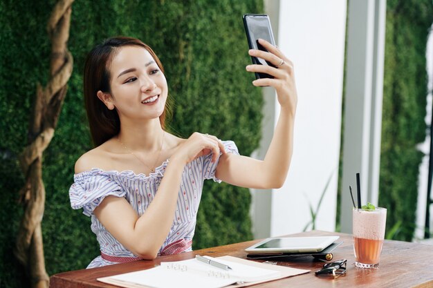 Junge Frau, die für selfie aufwirft