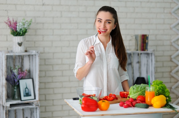 Junge Frau, die gesunden Gemüsesalat kocht