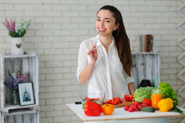 Junge Frau, die gesunden Gemüsesalat kocht