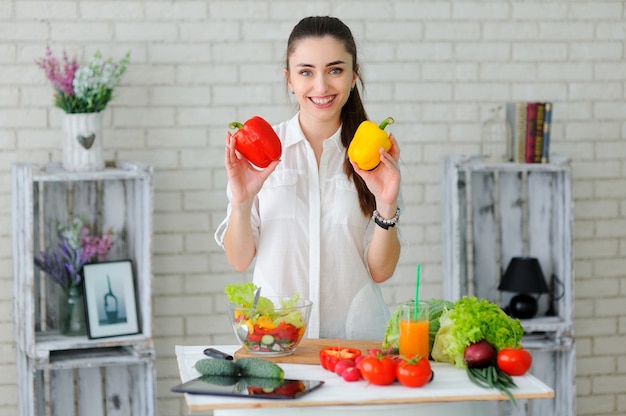 Foto junge frau, die gesunden gemüsesalat kocht