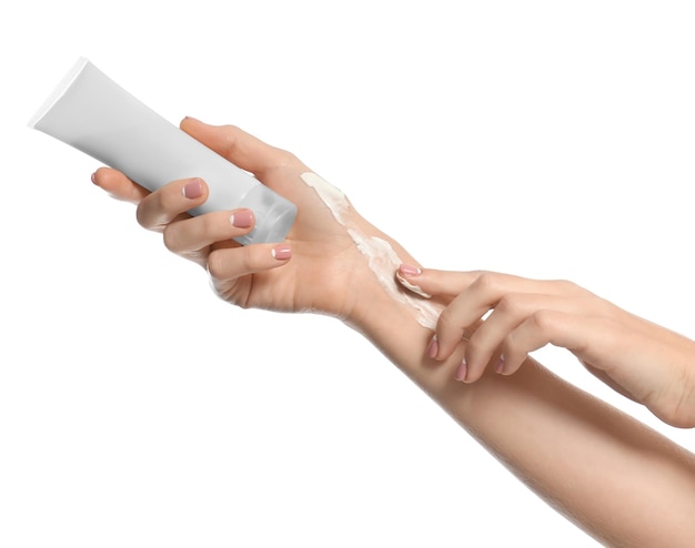 Junge Frau, die Handcreme auf weißen Hintergrund aufträgt