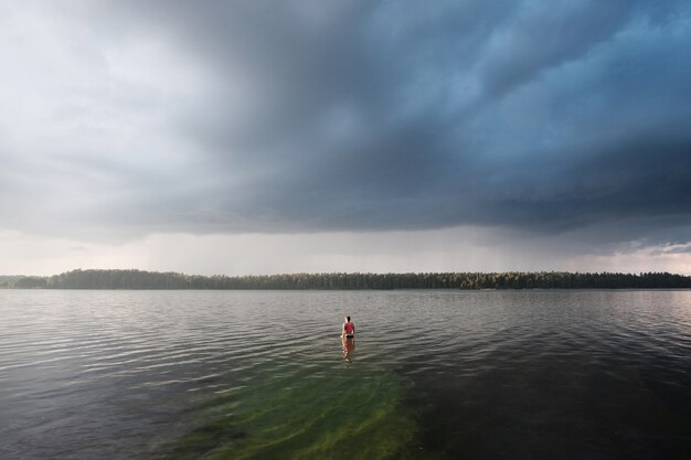 Junge Frau, die helles Spitzenschwimmen im See schwimmt.