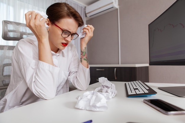 Junge Frau, die heraus bei der Arbeit betont