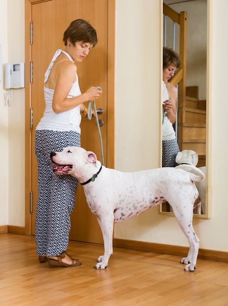 junge Frau, die Hund für einen Spaziergang nimmt