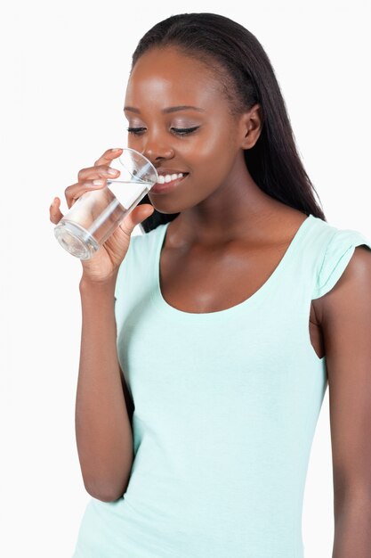 Junge Frau, die ihr Glas Wasser untersucht