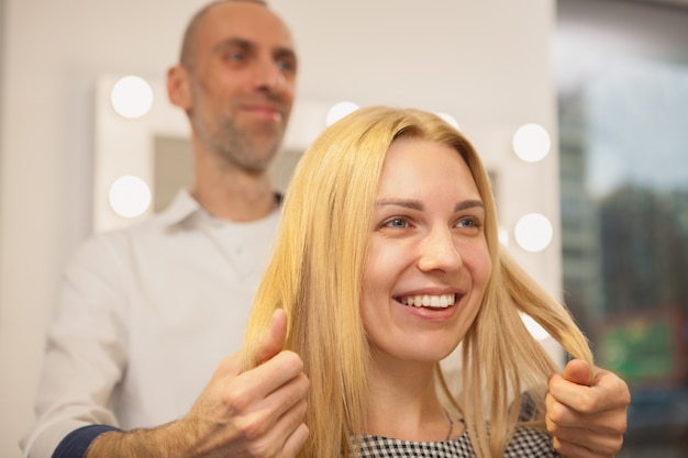 Junge Frau, die ihr Haar vom Friseur anreden lässt