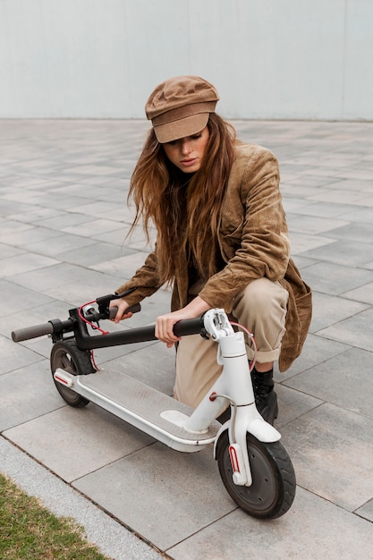 Foto junge frau, die ihren elektroroller hält