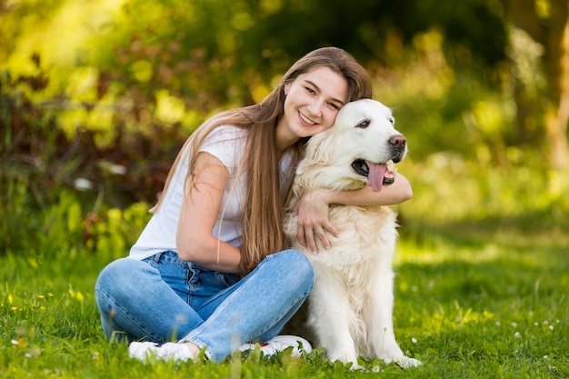 Junge frau, die ihren hund umarmt