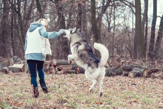 Junge Frau, die ihren Hundeschlittenhund umarmt