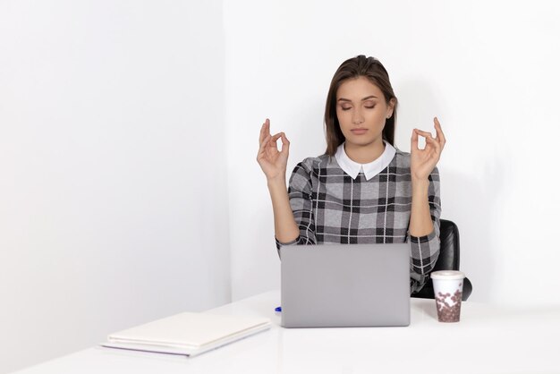 Junge Frau, die im Büro meditiert