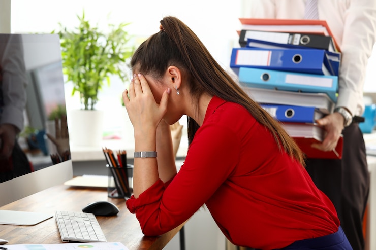 Foto junge frau, die im büro sitzt und sich gestresst und erschöpft fühlt