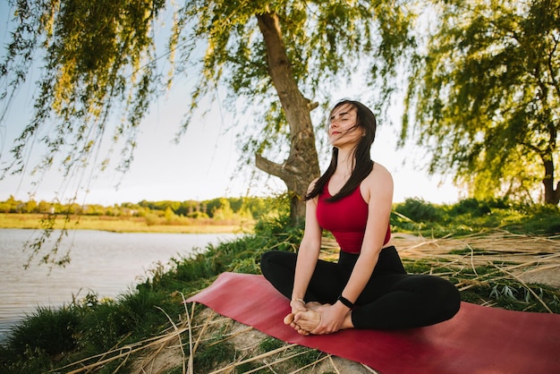 Junge Frau, die im Freien Yoga-Meditation macht